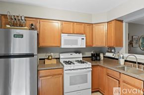 Clifton townhouse for rent - A kitchen with wooden cabinets and a stainless steel refrigerator.