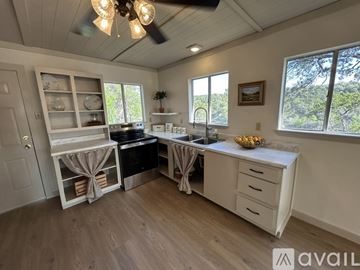 Spicewood house for rent - A kitchen with a ceiling fan and wooden flooring.