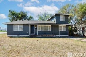 Lawton house for rent - A two-story house with a grey exterior and a black door.