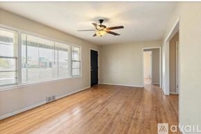 Lawton house for rent - A room with a ceiling fan and wooden flooring.