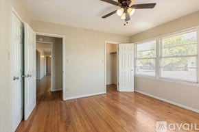 Lawton house for rent - A room with a ceiling fan and wooden floors.
