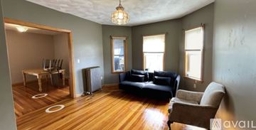 Medford apartment for rent - A living room with a black couch and a brown armchair.