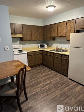 Stanton apartment for rent - A kitchen with wooden cabinets and a white refrigerator.