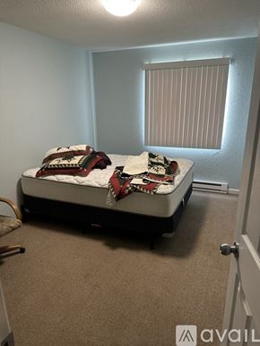 Stanton apartment for rent - A bedroom with a bed, carpet, and a window with blinds.