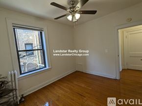 Chicago apartment for rent - A room with a window and a ceiling fan.