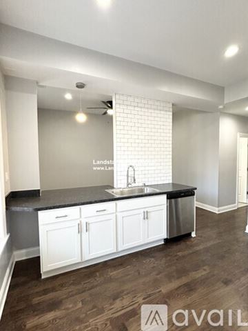 Chicago apartment for rent - A kitchen with white cabinets and a black countertop.