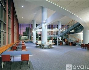 San Diego apartment for rent - A spacious atrium with tables, chairs, and a staircase.