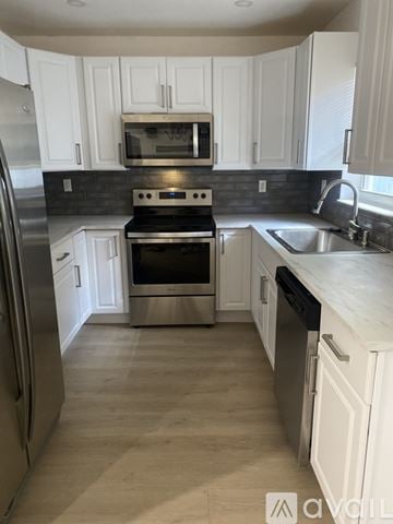Fort Lauderdale house for rent - A kitchen with white cabinets and a stainless steel refrigerator.