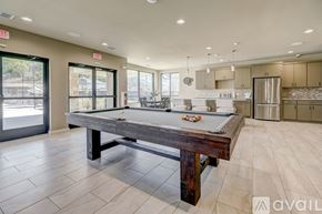 Willow Park townhouse for rent - A pool table is in the middle of a room with a kitchen in the background.