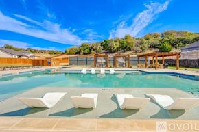 Willow Park townhouse for rent - A pool with white chairs and a wooden pergola.