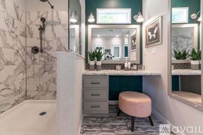 Stilwell apartment for rent - A bathroom with a marble tiled shower and a white bathtub.