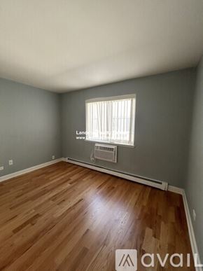 Chicago apartment for rent - A room with wooden flooring and a window with blinds.
