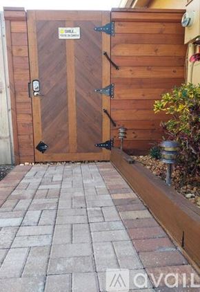 Hialeah apartment for rent - A wooden gate with a metal handle and a sign on it.