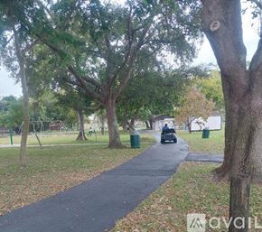 Hialeah apartment for rent - A park with a paved path and trees.