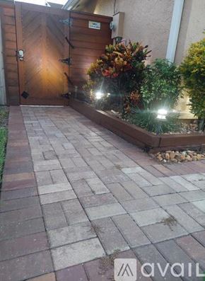 Hialeah apartment for rent - A wooden gate with a metal handle and a sign above it.