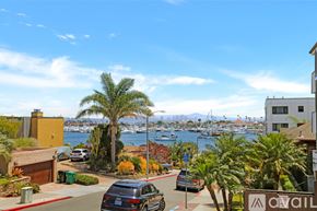 San Diego condo for rent - A view of a street with cars and palm trees.