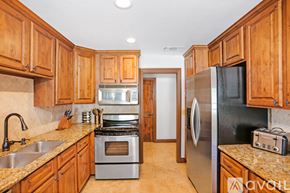 San Diego condo for rent - A kitchen with wooden cabinets and a black refrigerator.