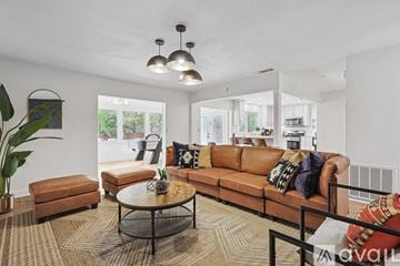 North Richland Hills house for rent - A living room with a brown leather couch and a glass coffee table.
