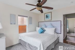San Diego house for rent - A bedroom with a white bed and a ceiling fan.