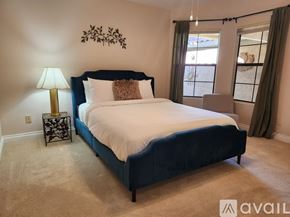 Palm Desert house for rent - A bedroom with a large bed and a lamp on a side table.