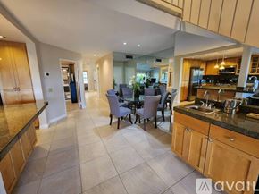 Palm Desert house for rent - A kitchen with a dining table and chairs in the middle of the room.