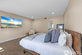 La Quinta house for rent - A bedroom with a large bed and a painting on the wall.