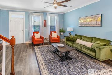 Savannah house for rent - A living room with a green couch, a coffee table, and a painting on the wall.