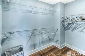 Savannah house for rent - A spacious walk-in closet with wooden floors and white shelving.