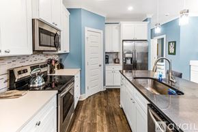 Savannah house for rent - A kitchen with white cabinets and a blue wall.