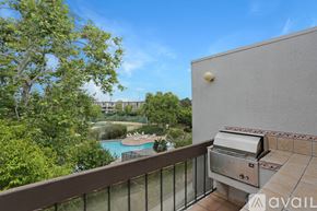 San Diego condo for rent - A balcony with a grill and a pool in the background.