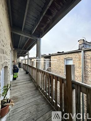 Chicago apartment for rent - A wooden balcony with a railing and a few potted plants.