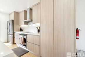 Miami house for rent - A kitchen with wooden cabinets and a stainless steel refrigerator.