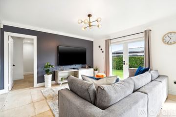 Miami house for rent - A living room with a grey couch and a television.