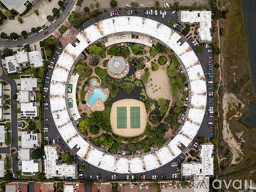 San Diego condo for rent - A living room with a brown couch and a round mirror on the wall.