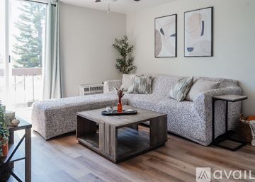 San Diego condo for rent - A living room with a grey couch, a wooden coffee table, and two abstract paintings on the wall.