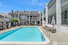 San Diego condo for rent - A swimming pool is surrounded by a concrete patio and a building.