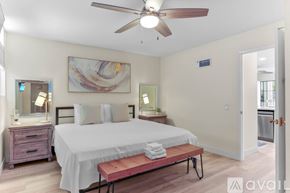 San Diego condo for rent - A bedroom with a bed, nightstand, and a painting on the wall.