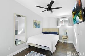 Imperial Beach house for rent - A bedroom with a large bed and a ceiling fan.