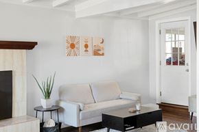 Imperial Beach house for rent - A living room with a grey couch, a black coffee table, and a fireplace.