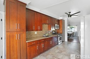Imperial Beach house for rent - A kitchen with wooden cabinets and a white refrigerator.
