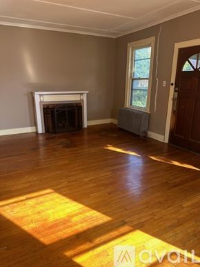 Oswego townhouse for rent - A room with a fireplace and wooden floors.