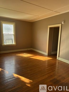 Oswego townhouse for rent - A room with wooden floors and a window letting in sunlight.