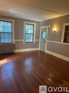 Oswego townhouse for rent - A room with wooden floors and a window with blinds.