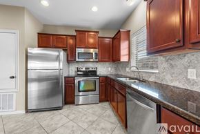 College Station apartment for rent - A kitchen with brown cabinets and a stainless steel refrigerator.