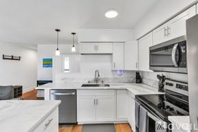 San Diego condo for rent - A modern kitchen with white cabinets and stainless steel appliances.