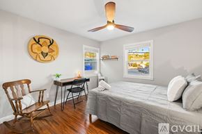 San Diego house for rent - A kitchen with white cabinets and a white island with two brown barstools.