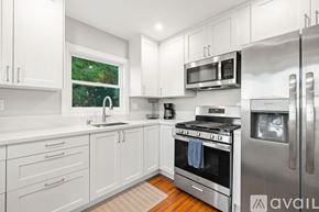 San Diego house for rent - A kitchen with white cabinets and a refrigerator.