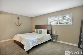 San Diego condo for rent - A bedroom with a bed, a small table, and a window with blinds.