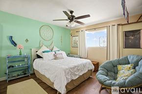 San Diego condo for rent - A bedroom with a bed, a chair, and a dream catcher on the wall.