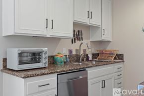 San Diego condo for rent - A kitchen with white cabinets and a granite countertop.